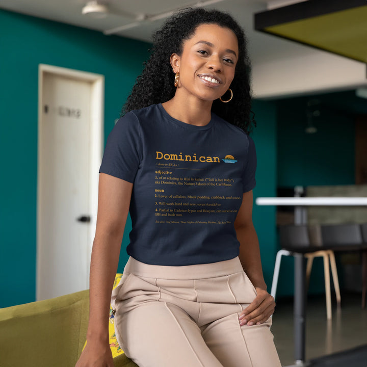 Brown skinned woman wearing a "Dominican Defined" t-shirt in navy color, with gold text, by Embrace Dominica