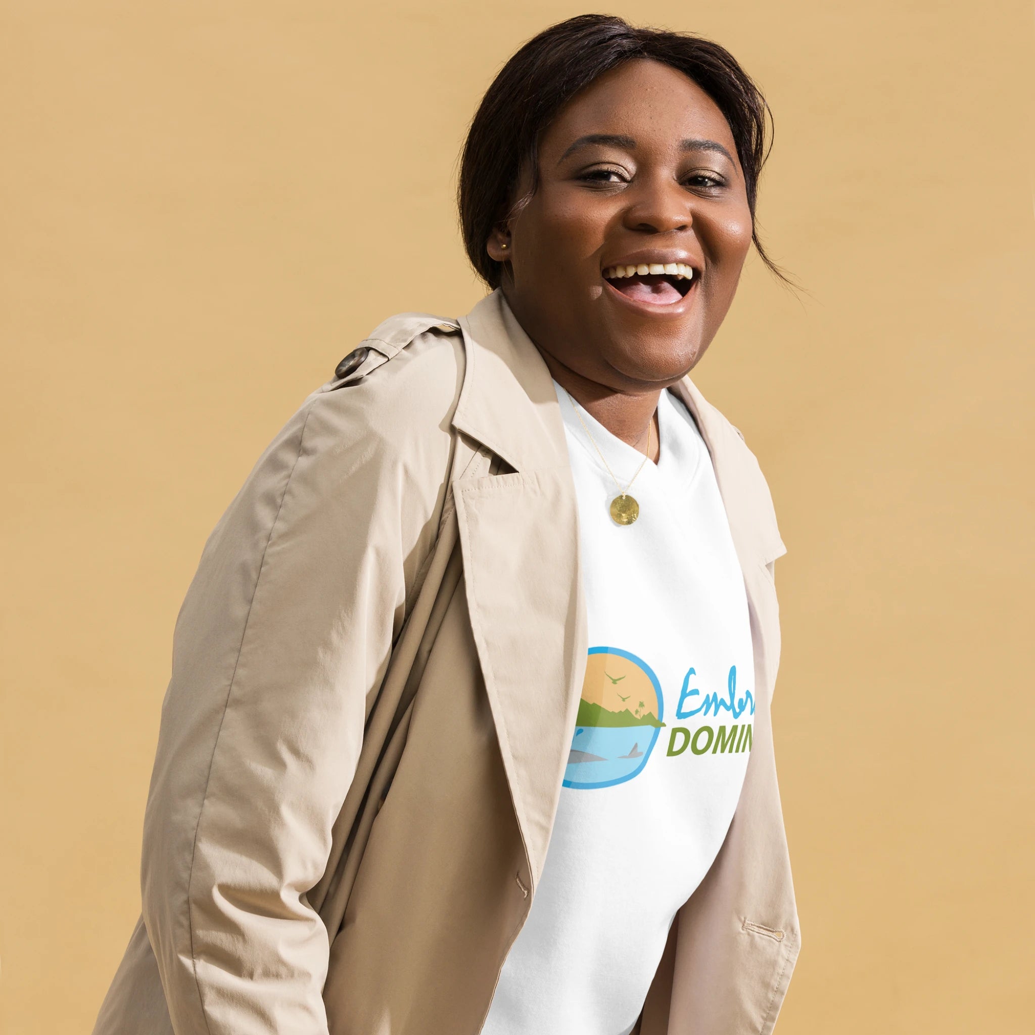 Dark skinned female model wearing an "Embrace Dominica" white colored sweatshirt with the colored Embrace Dominica logo on the front.