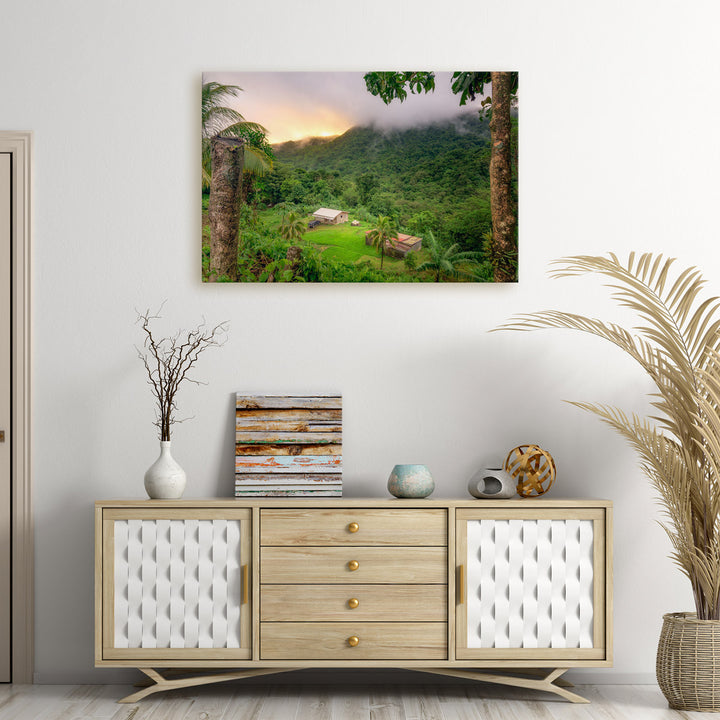 A canvas print of "Fire Beyond the Mountain" by Yuri A Jones on a white wall above a wooden desk.