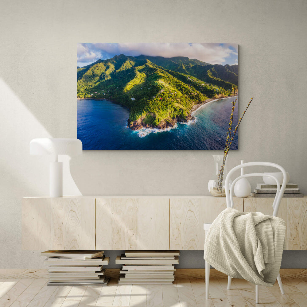 A canvas print of "Pointe Carib from Above I" by Yuri A Jones on a concrete wall, hung above a modern desk.