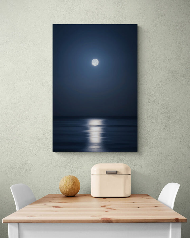A canvas print of "Full Moon [April 2022]" by Yuri A Jones on a light colored wall, hung over a kitchen table.